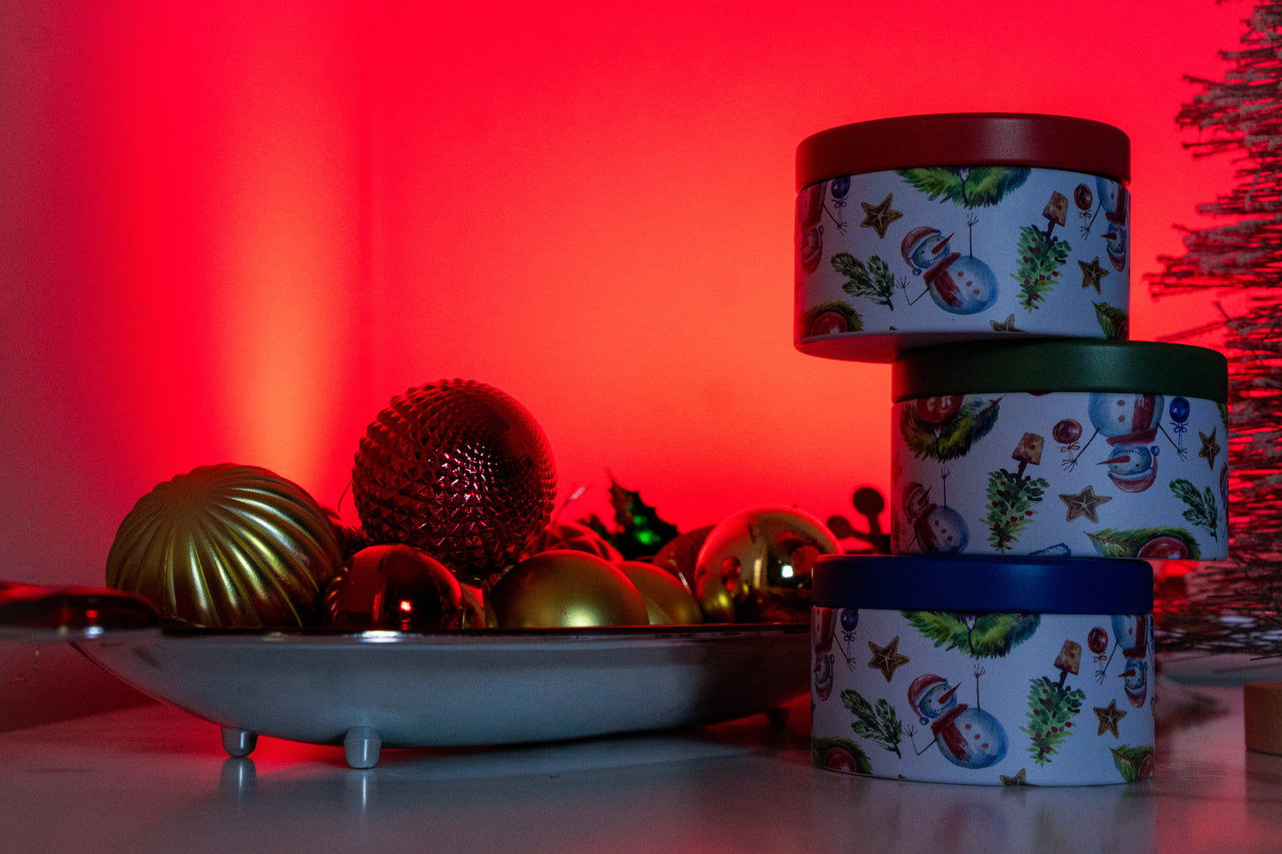 Decorative tins with Christmas designs on a red background