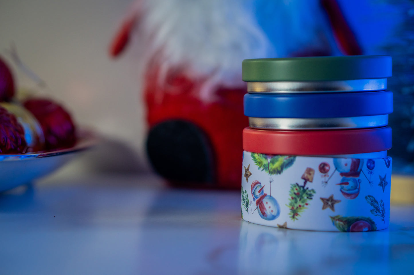 Stack of colorful containers with a Christmas-themed design on a blurred background