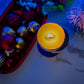 Candle with colorful ornaments on a textured surface